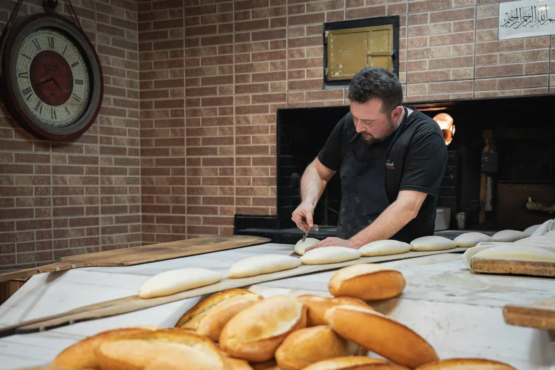 Baker shaping dough in a bakery