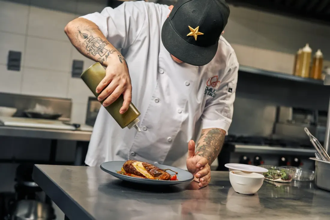 Cook plating food in a kitchen