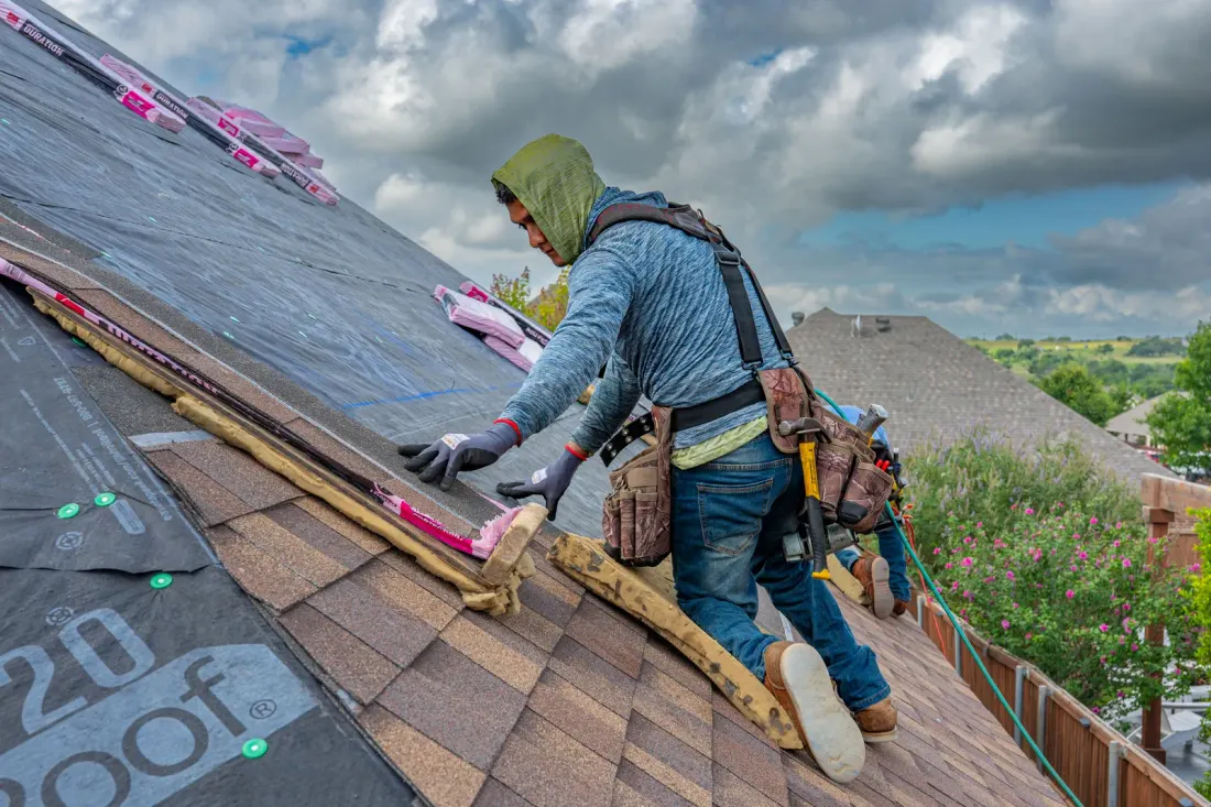 Roofer installing shingles